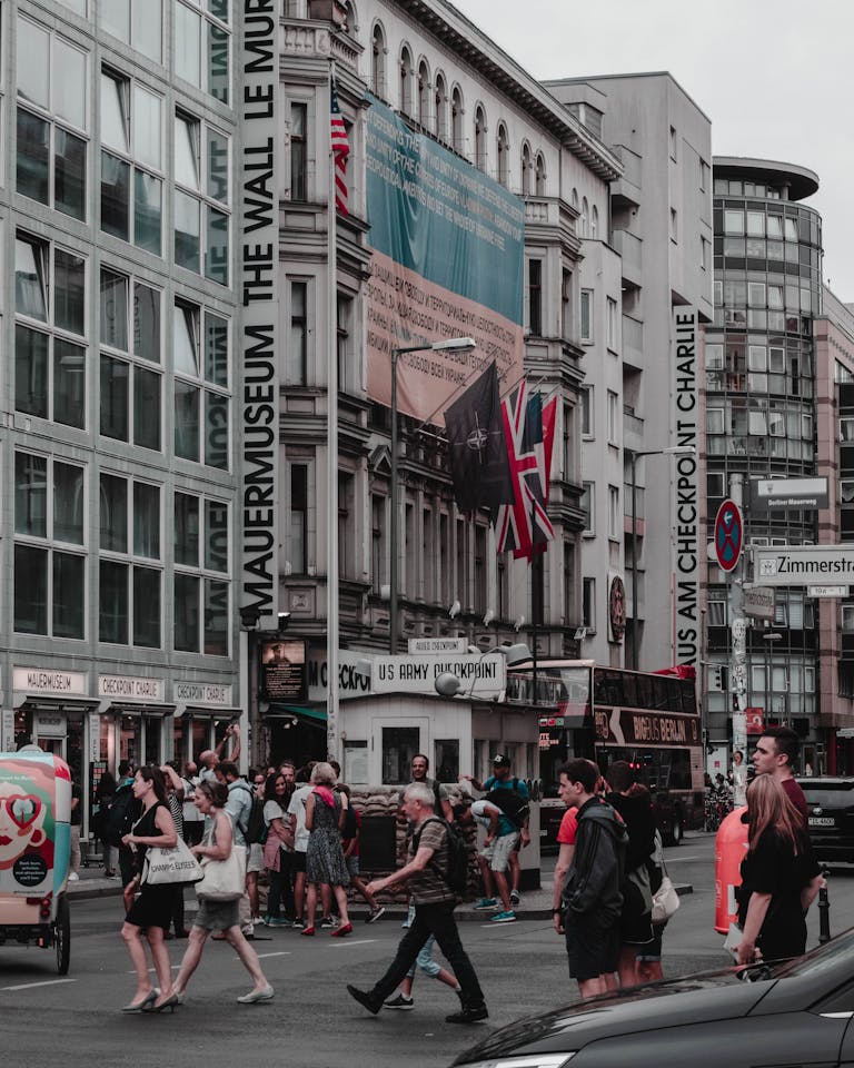 A bustling day at Checkpoint Charlie in Berlin with tourists and locals crossing.