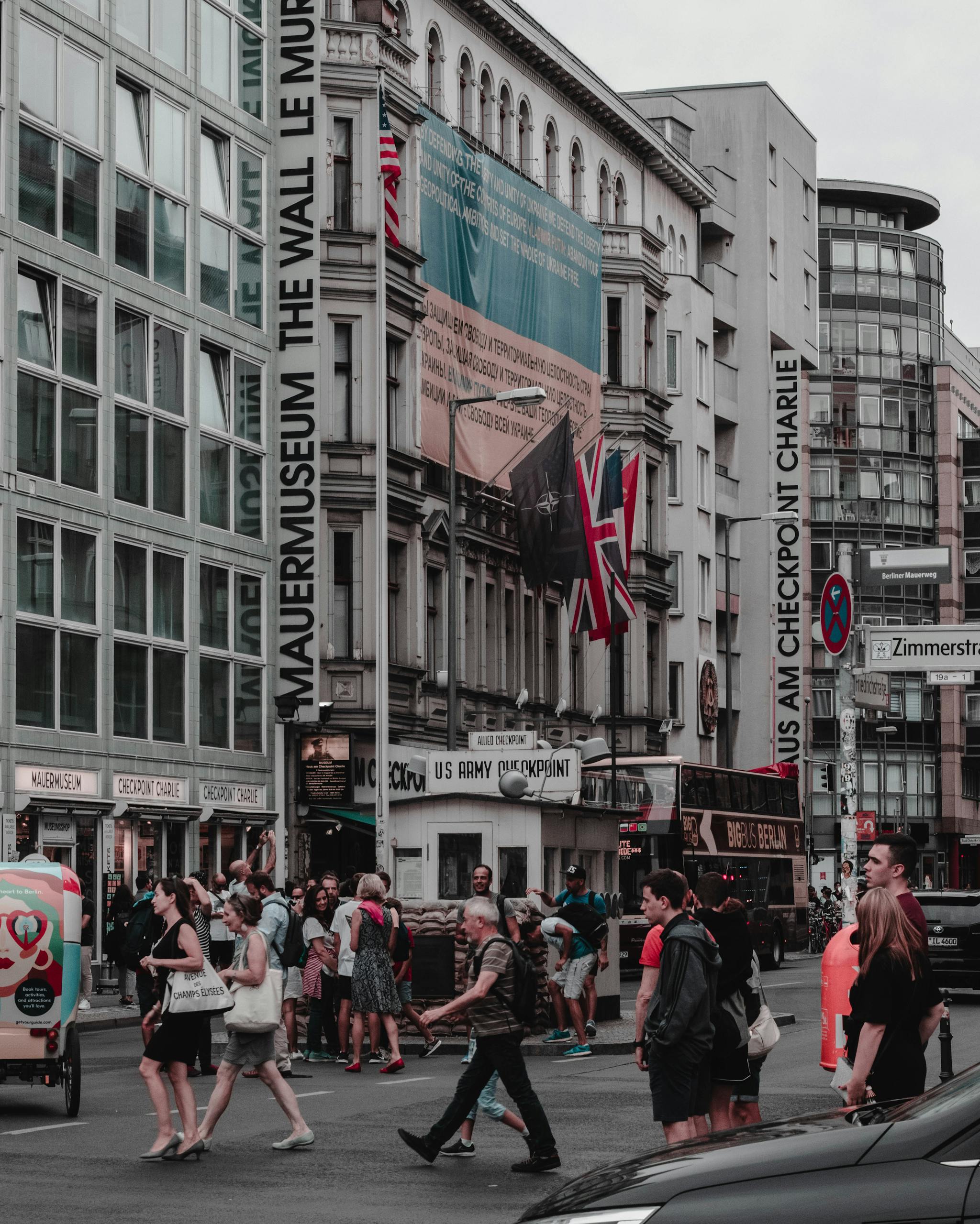 A bustling day at Checkpoint Charlie in Berlin with tourists and locals crossing.