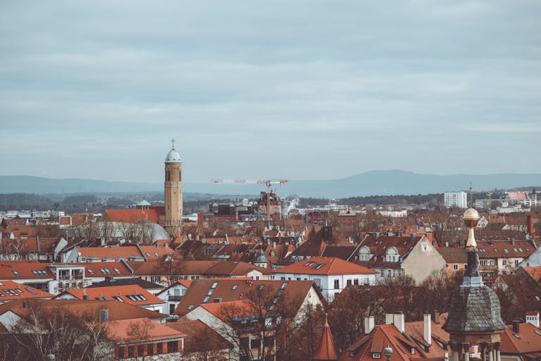Explore the charming red rooftops of historic Bamberg under a cloudy sky. A scenic blend of architecture and culture.