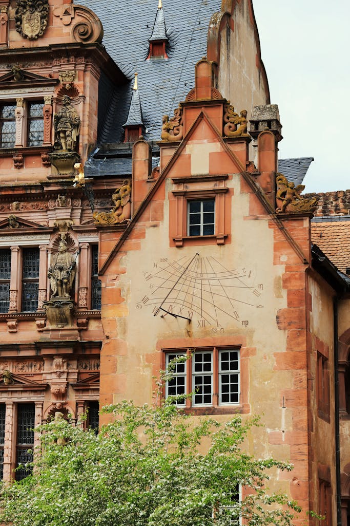 Sundial on a historic building facade in Heidelberg Castle, showcasing classic German architecture.